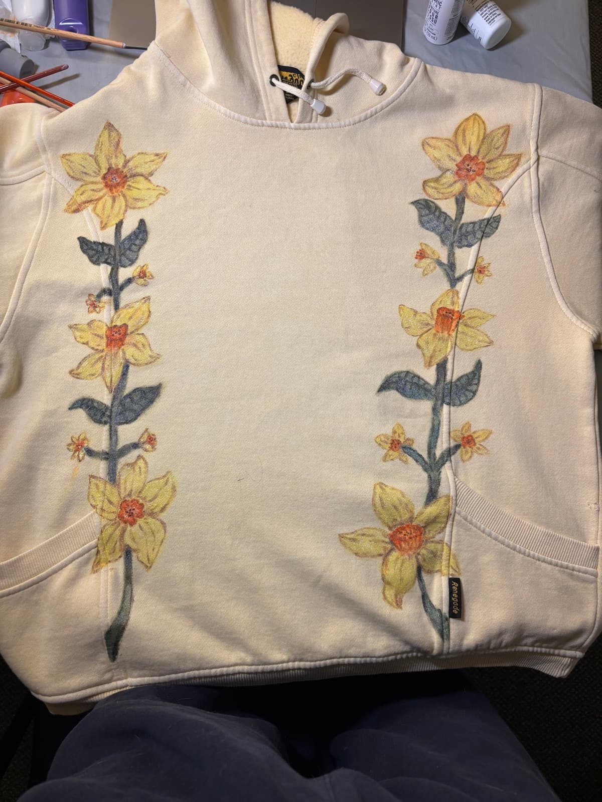 Hand-painted daffodil design, front view, on a custom sweatshirt by Madeleine MacNutt