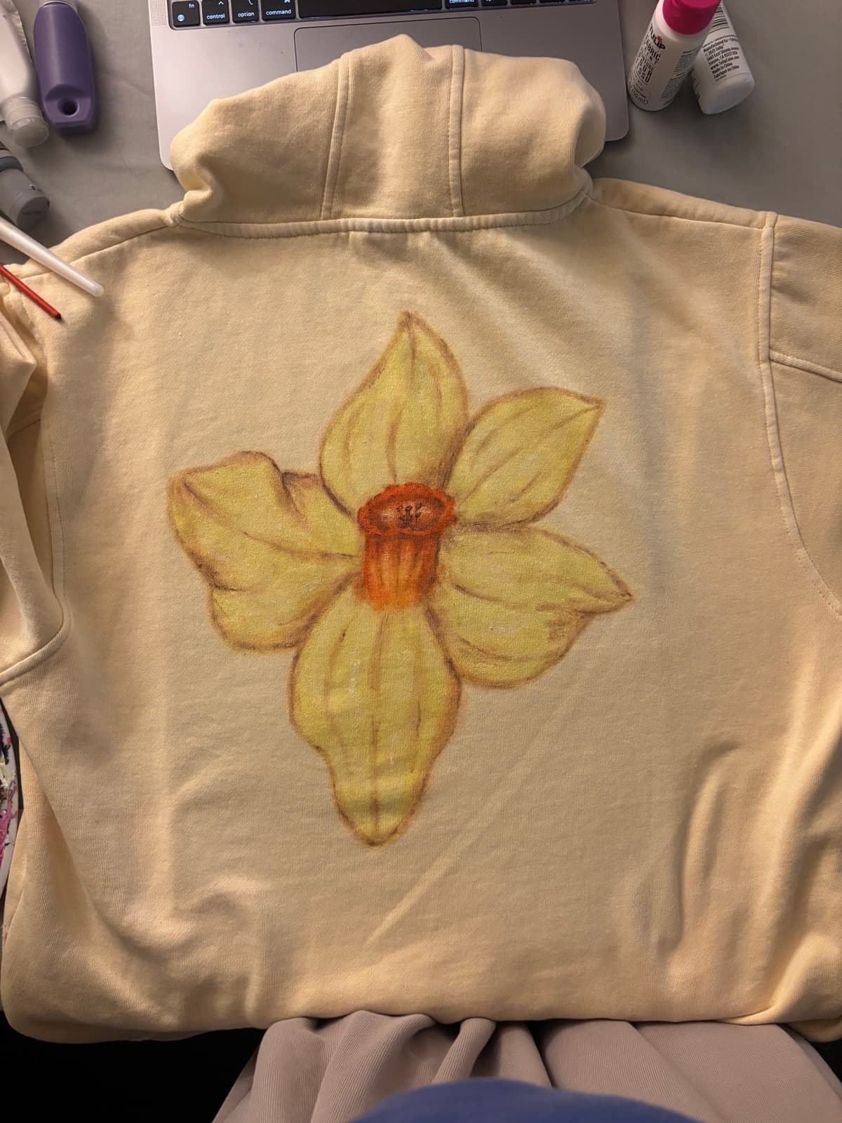 Hand-painted daffodil design, back view, on a custom sweatshirt by Madeleine MacNutt